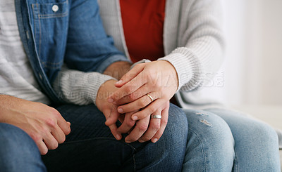 Buy stock photo Cropped shot of an unrecognizable couple sitting together at home