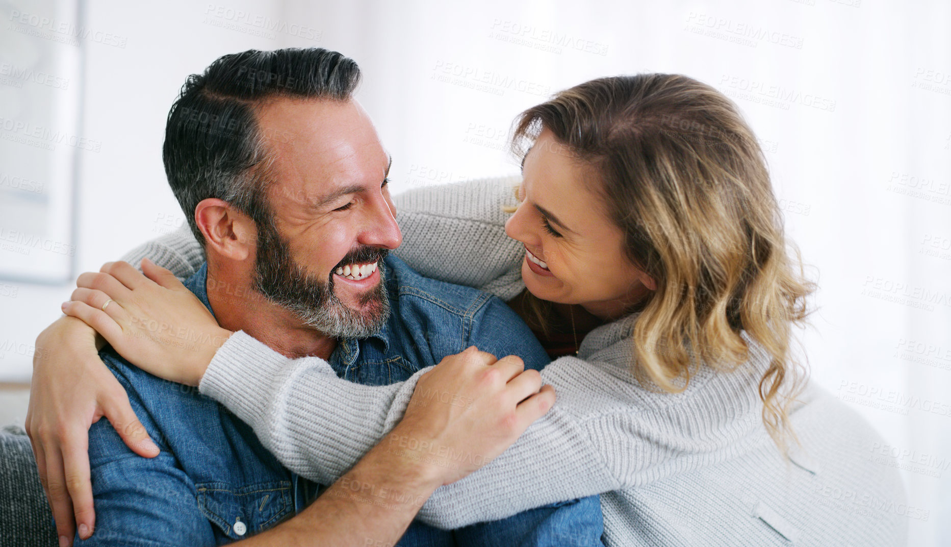 Buy stock photo Cropped shot of an affectionate couple relaxing together at home