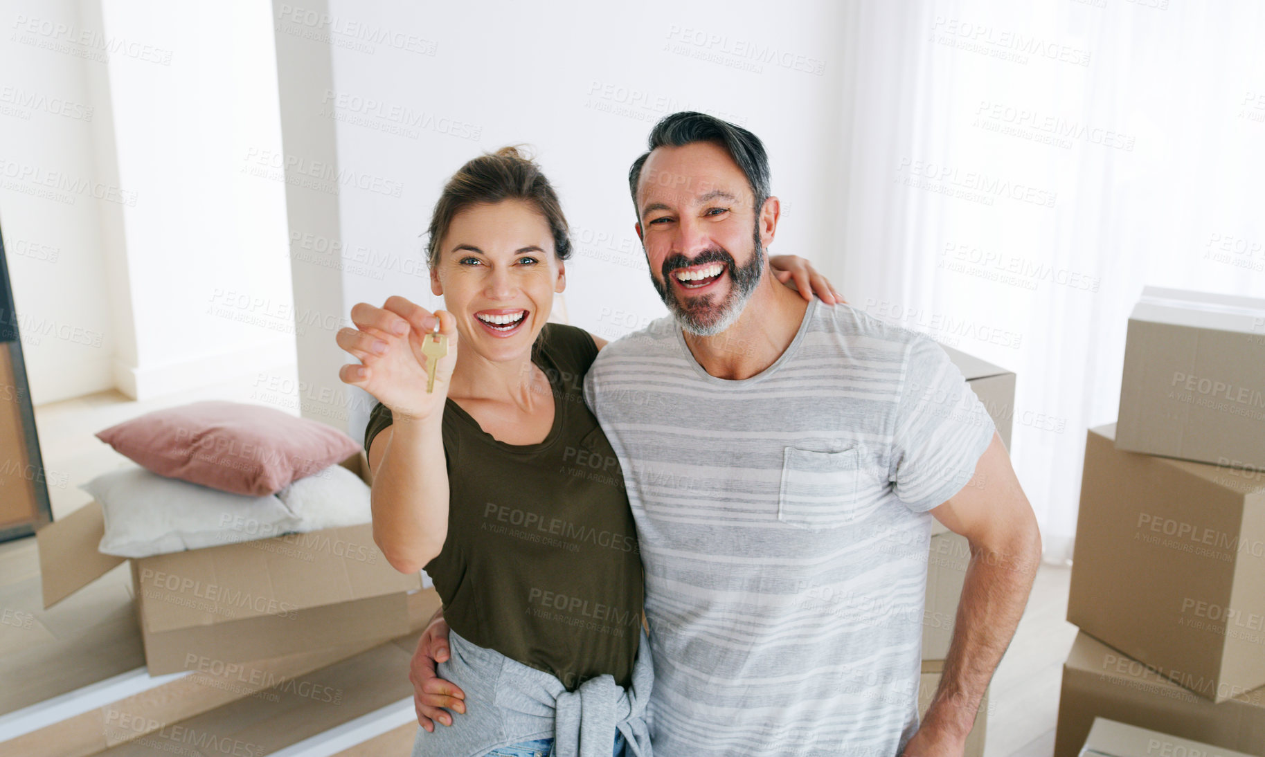 Buy stock photo Shot of a couple holding the key to their new home