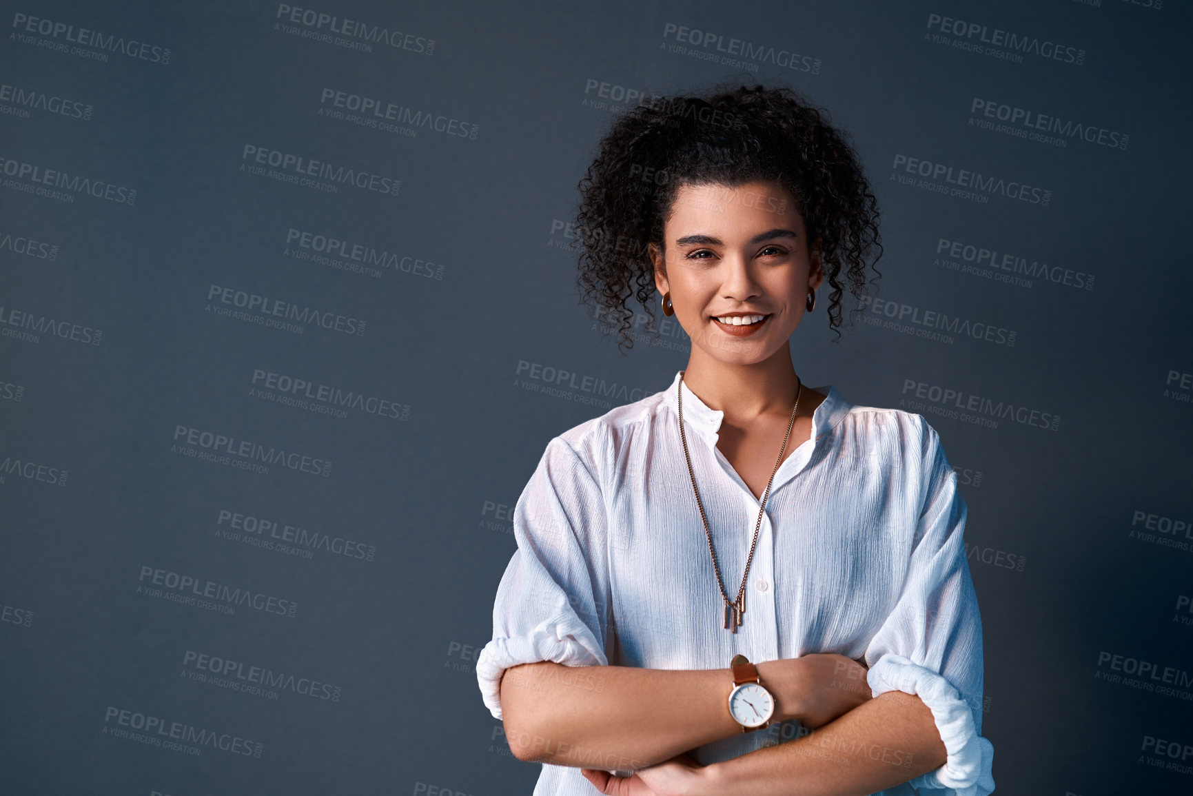 Buy stock photo Cropped portrait of an attractive young businesswoman standing against a gray background alone with her arms folded