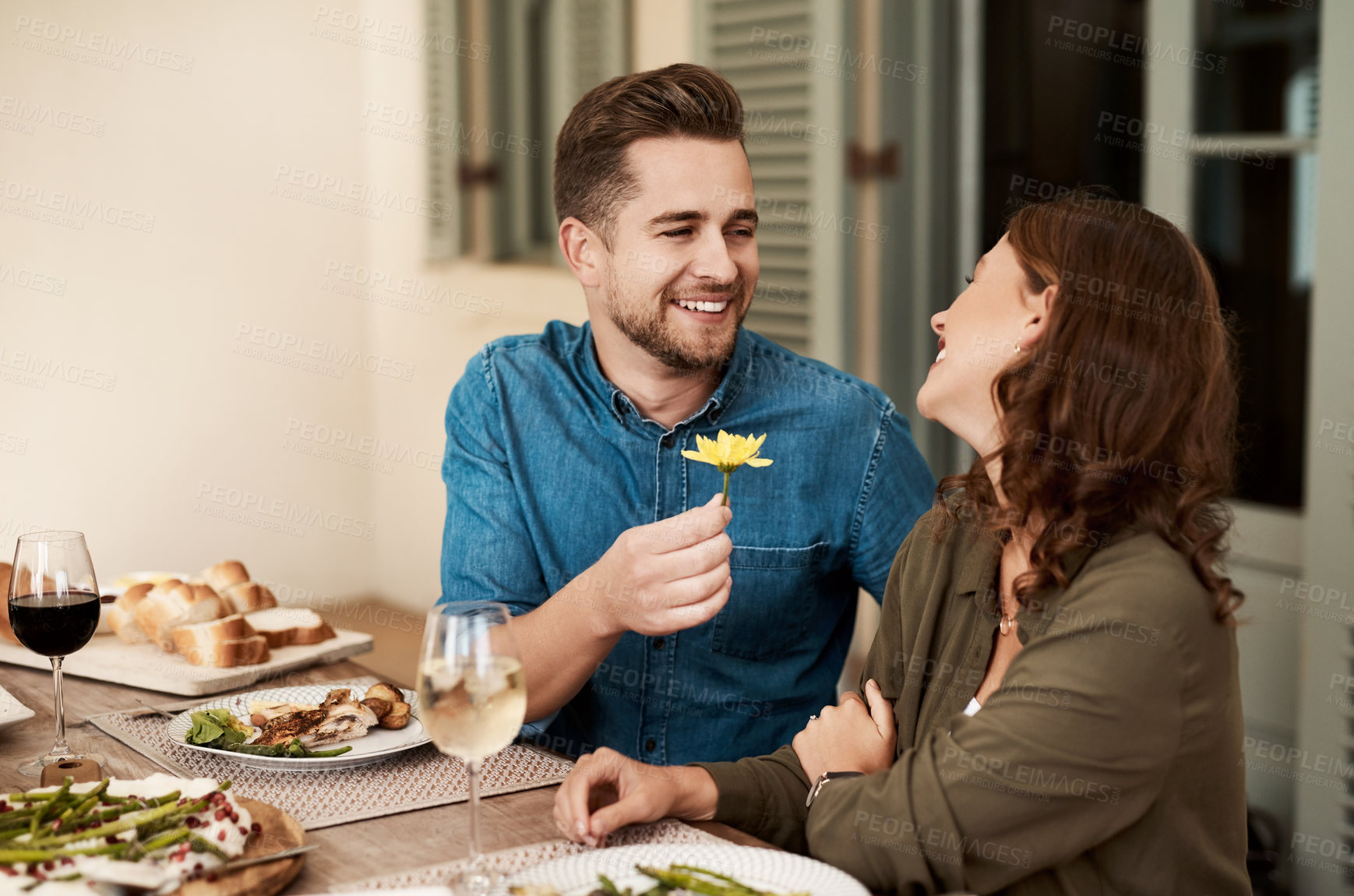 Buy stock photo Gift, happy couple and flower on dinner date for love, support and romance at anniversary celebration. Giving, woman and man with present at lunch for care, connection or commitment together in house