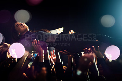 Buy stock photo Crowd surfing, concert and woman with people holding, festival energy and lens flare at a night club party. New years celebration, crazy and audience with support for a girl at a music festival