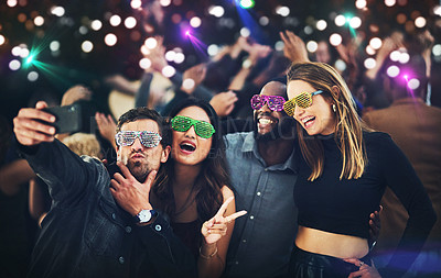 Buy stock photo Cropped shot of a diverse group of young friends taking a selfie together at a party at night