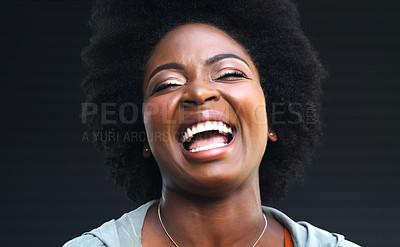 Buy stock photo Shot of a young woman laughing while posing against a dark background