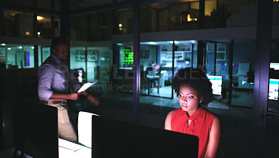 Buy stock photo Shot of two businesspeople working late at the office