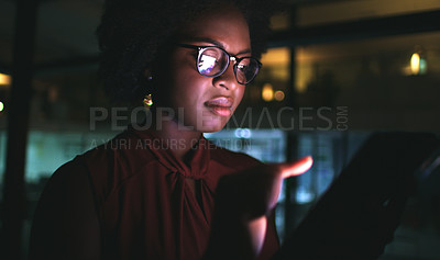 Buy stock photo Cropped shot of a businesswoman using a digital tablet while working late at the office