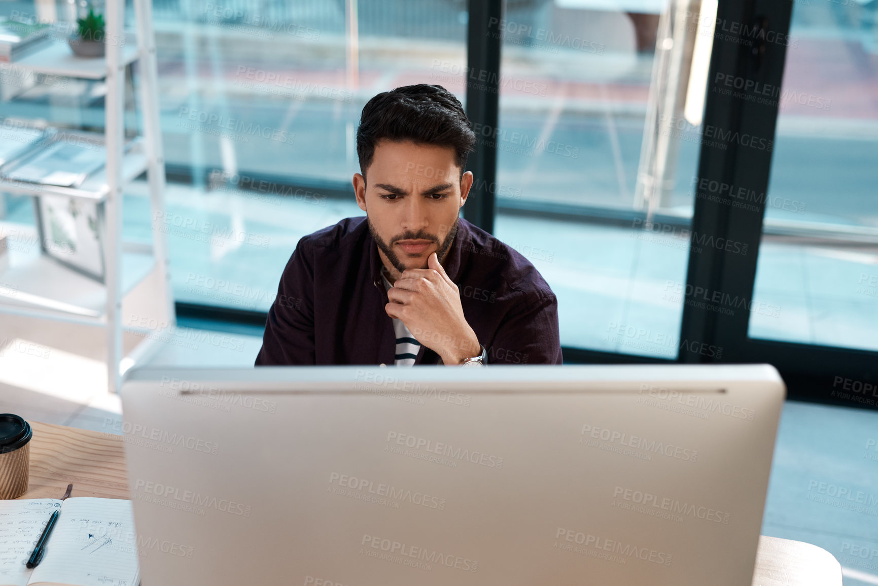 Buy stock photo Serious, computer and a business man thinking while working at a desk and online for research. Male entrepreneur person confused while reading email or data analytics with internet connection