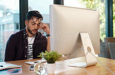 Buy stock photo Cropped shot of a handsome young businessman feeling overwhelmed and falling asleep while sitting at his computer in his office