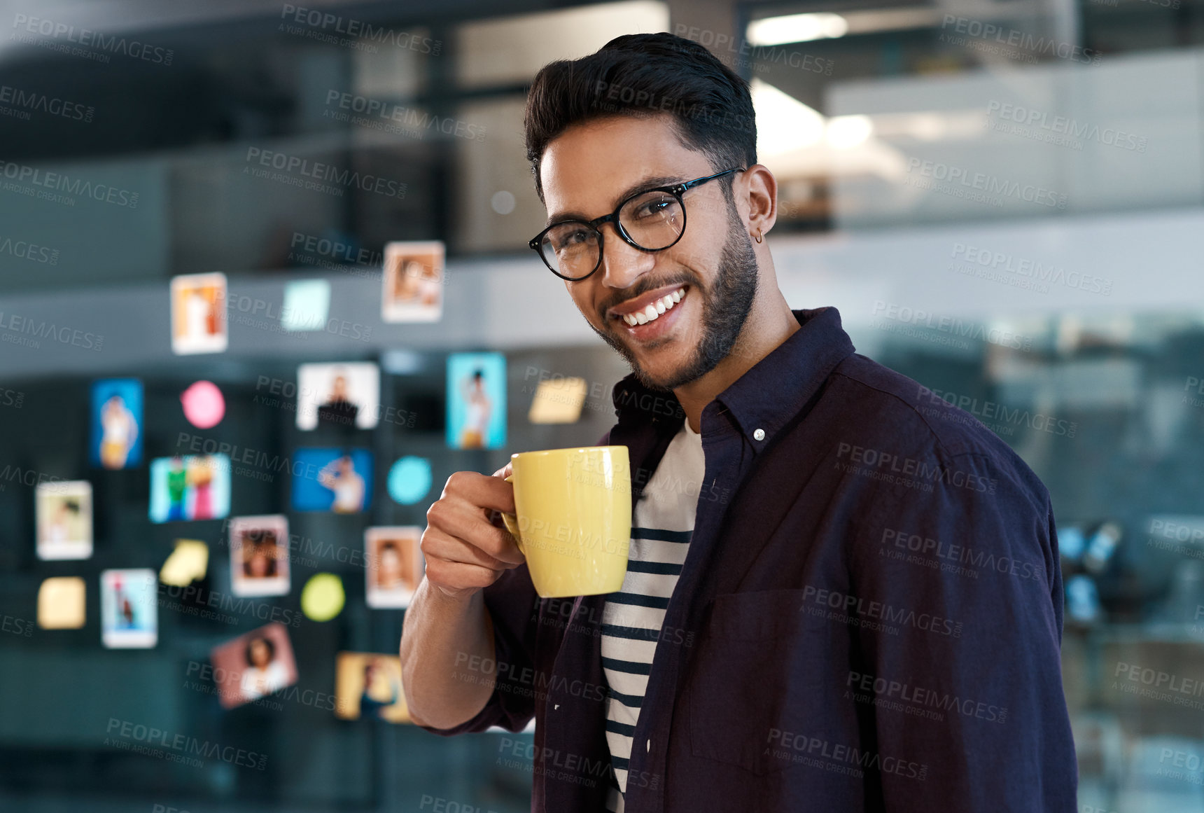 Buy stock photo Cropped portrait of a handsome young businessman wearing spectacles and standing in his office while drinking a cup of coffee