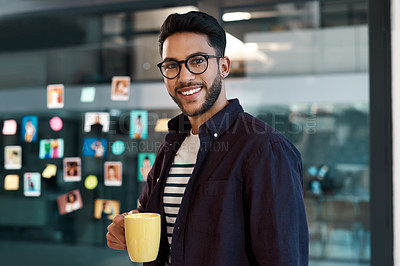 Buy stock photo Cropped portrait of a handsome young businessman wearing spectacles and standing in his office while drinking a cup of coffee