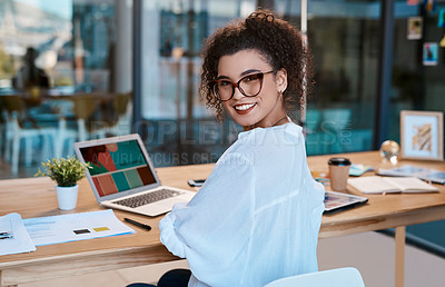 Buy stock photo Cropped portrait of an attractive young businesswoman wearing spectacles and sitting alone while working in her office