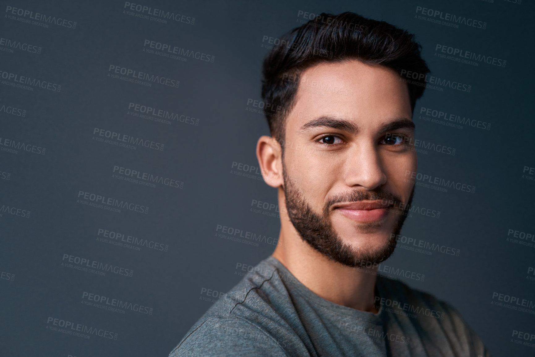 Buy stock photo Cropped portrait of a handsome young businessman standing against a gray background alone in the studio