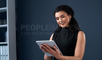 Buy stock photo Cropped shot of an attractive young businesswoman standing alone and using a tablet against a gray background in the studio