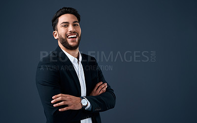 Buy stock photo Cropped portrait of a handsome young businessman standing against a gray background alone with his arms folded