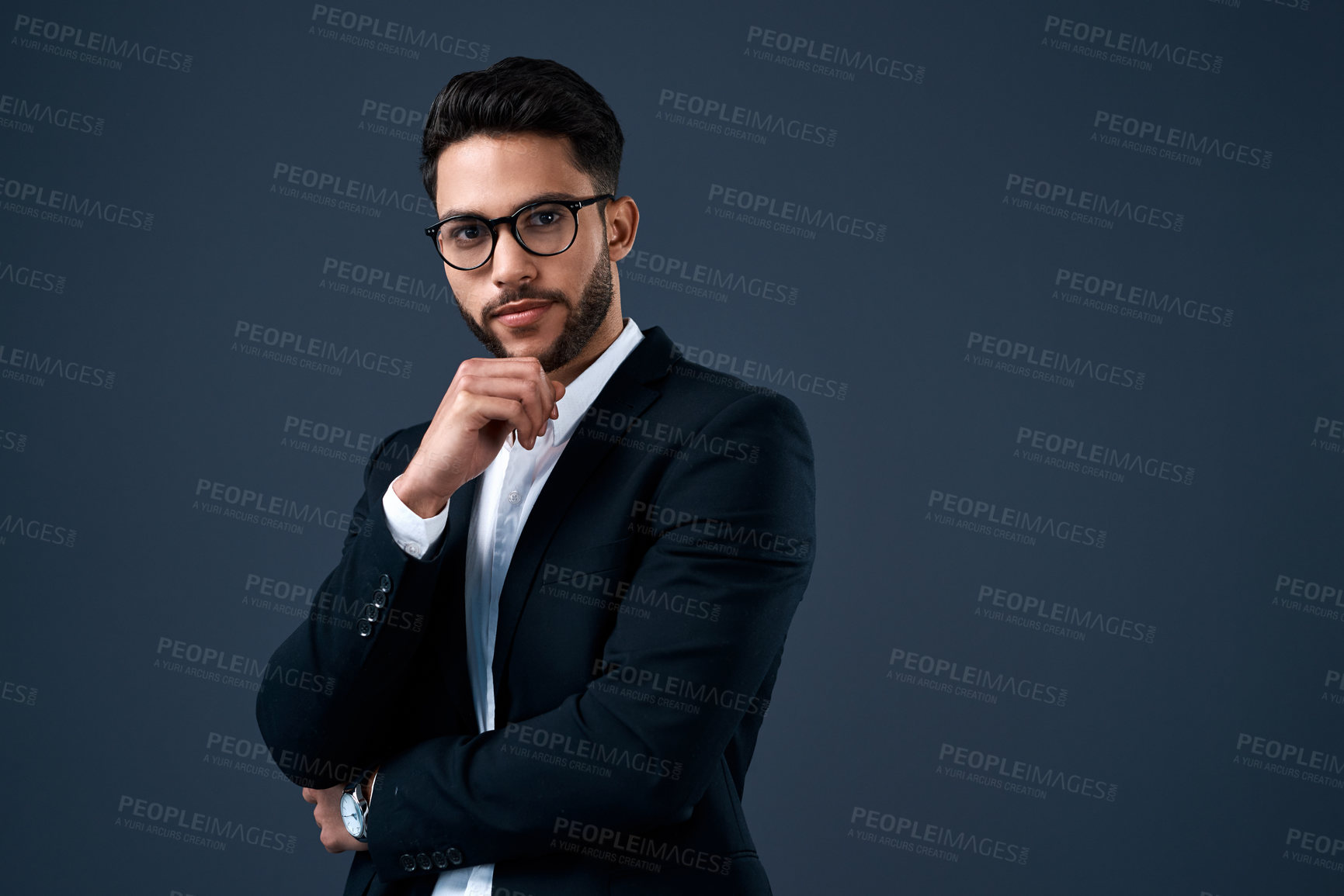 Buy stock photo Cropped portrait of a handsome young businessman wearing spectacles and standing alone against a gray background