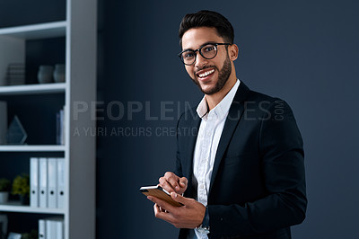 Buy stock photo Cropped portrait of a handsome young businessman standing alone against a gray studio background and texting on his cellphone