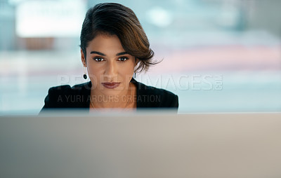 Buy stock photo Cropped shot of an attractive young businesswoman sitting alone and working on her computer in the office