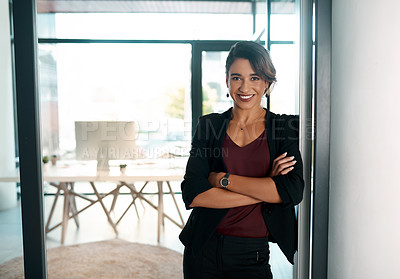 Buy stock photo Cropped portrait of an attractive young businesswoman standing alone with her arms folded in the office