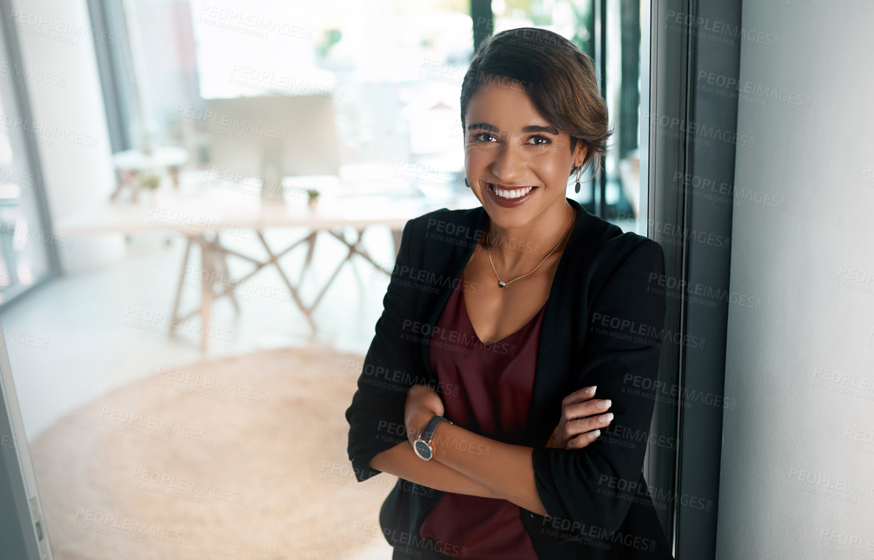 Buy stock photo Cropped portrait of an attractive young businesswoman standing alone with her arms folded in the office