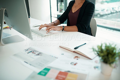 Buy stock photo Cropped shot of an unrecognizable businesswoman sitting alone in her office and using her computer