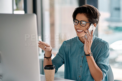 Buy stock photo Cropped shot of an attractive young businesswoman sitting in her office and talking on her cellphone while using her computer