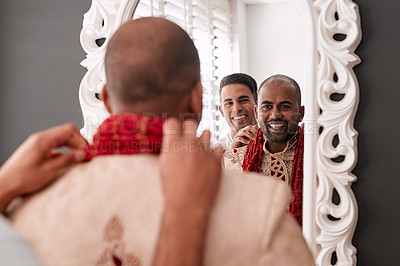 Buy stock photo Cropped shot of a young best man helping the groom with getting dressed while standing in front of the mirror on the wedding day