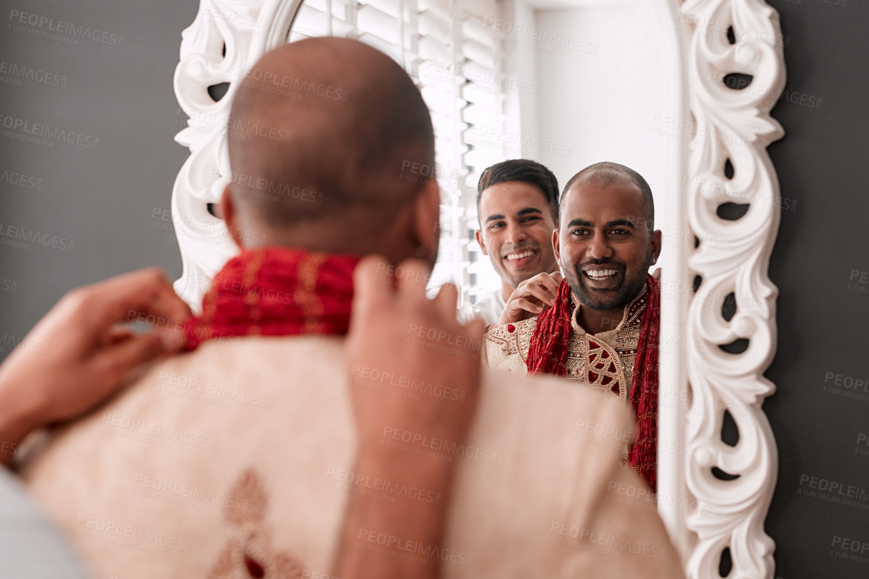 Buy stock photo Cropped shot of a young best man helping the groom with getting dressed while standing in front of the mirror on the wedding day