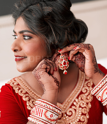 Buy stock photo Cropped shot of a beautiful young bride putting on her earrings in preparation for her wedding