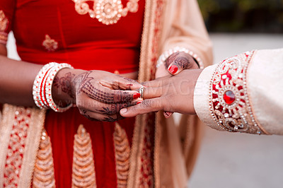 Buy stock photo Cropped shot of an unrecognizable bride slipping a ring on to her groom's finger on their wedding day