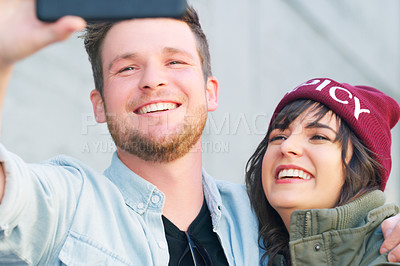 Buy stock photo Cropped shot of an affectionate young couple taking selfies together outdoors