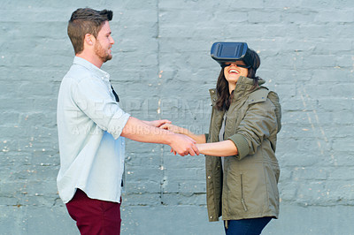 Buy stock photo Cropped shot of an affectionate young couple having fun and using a virtual reality headset together outdoors