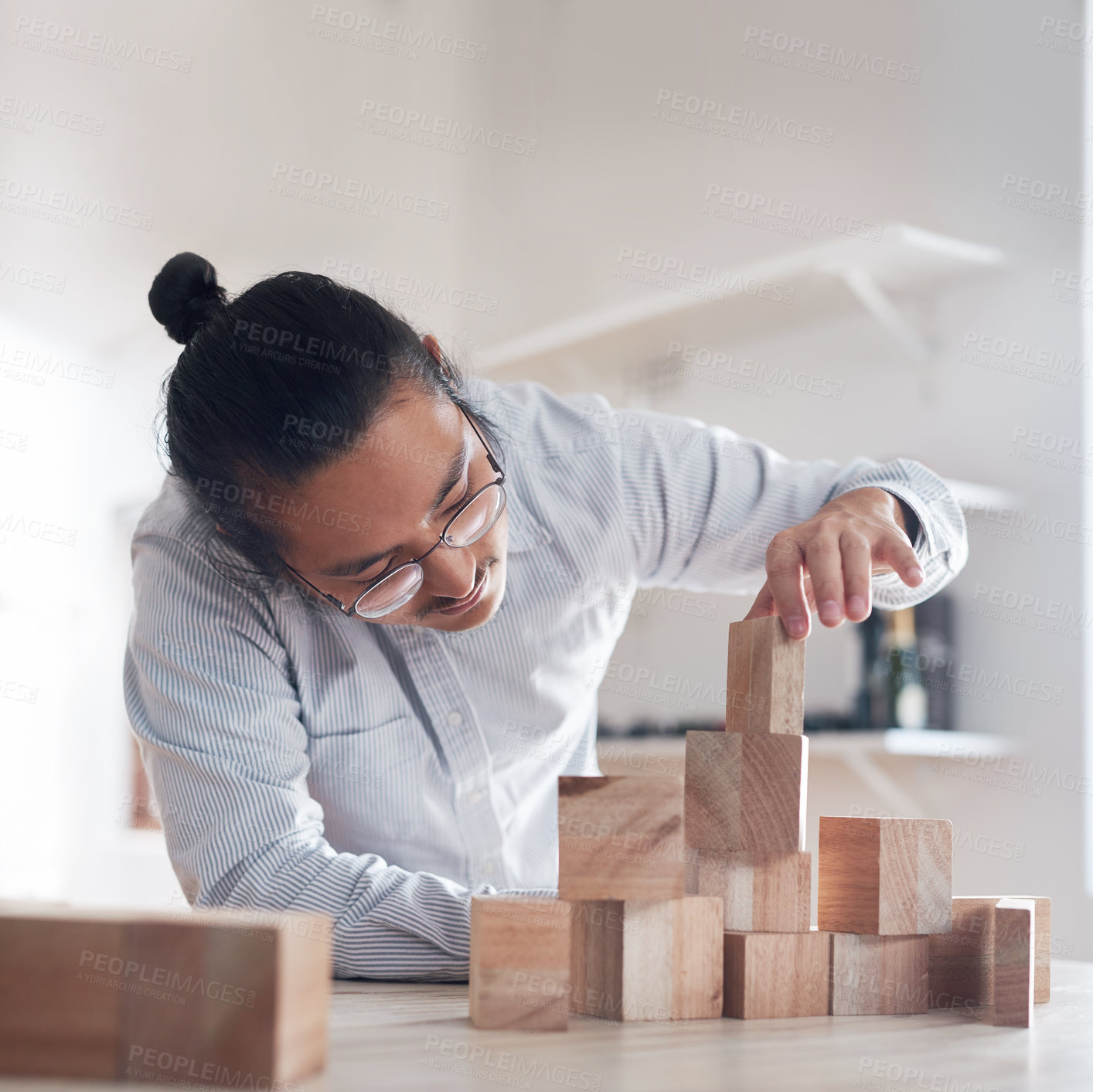 Buy stock photo Man, office and building block game, thinking challenge and design innovation for balance and construction. Engineering, architecture and Japanese designer with wood blocks for problem solving games.