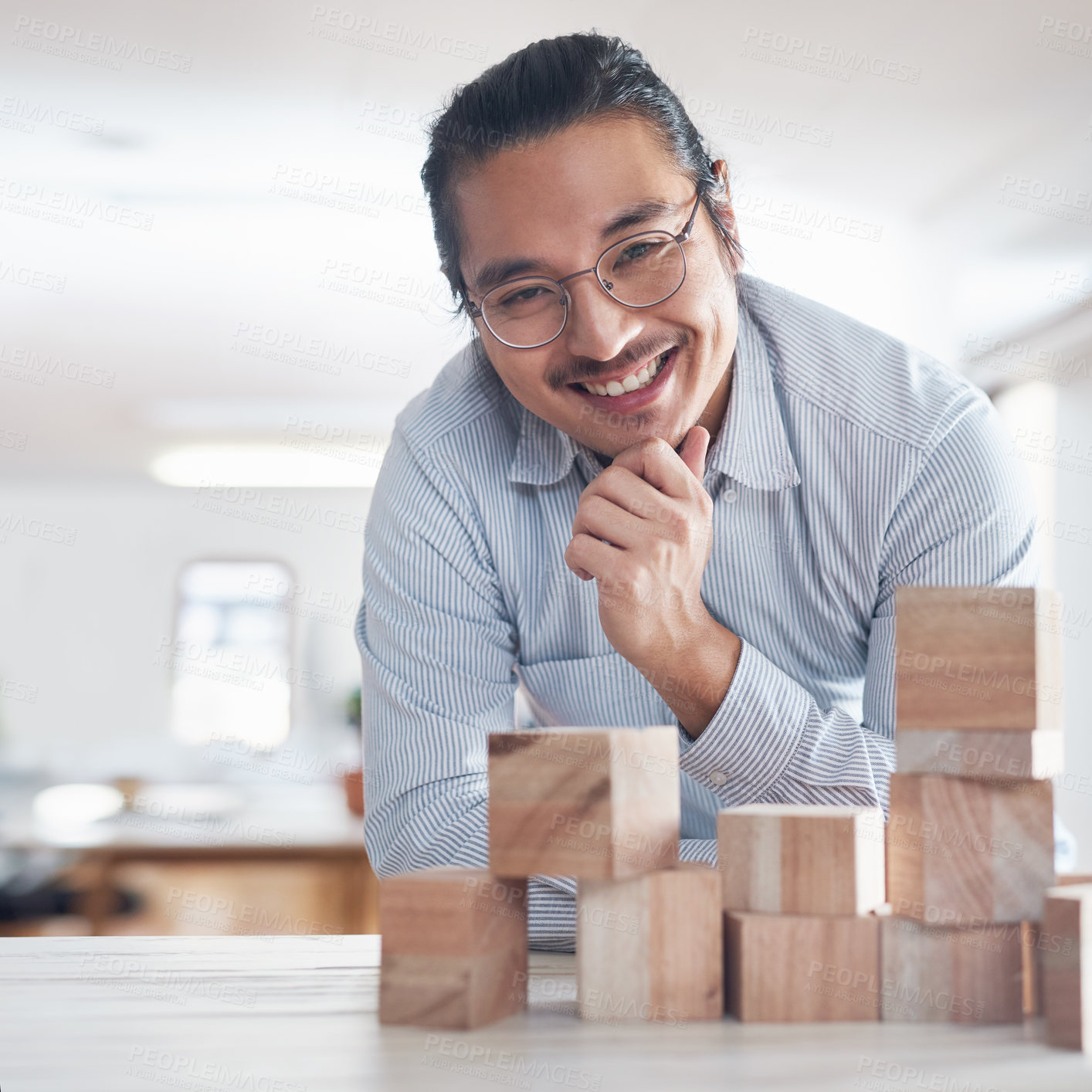 Buy stock photo Design, strategy and portrait of man with building blocks in office, thinking and innovation for balance with smile. Engineering, challenge and asian designer with wood block game for problem solving