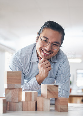 Buy stock photo Portrait of businessman with smile, growth and blocks, thinking challenge game and design balance. Engineering, architecture and happiness, asian designer with building block problem solving games.