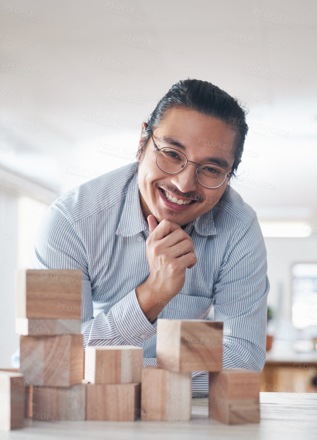 Buy stock photo Portrait of businessman with smile, growth and blocks, thinking challenge game and design balance. Engineering, architecture and happiness, asian designer with building block problem solving games.