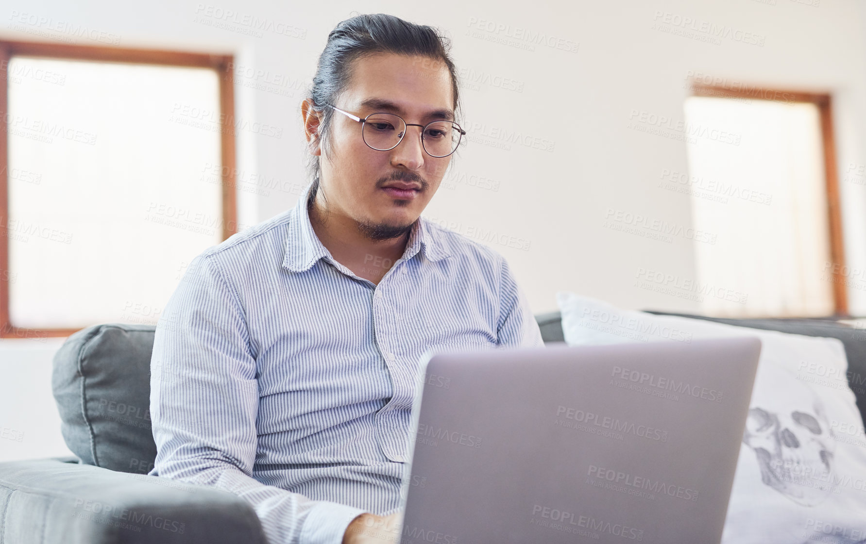 Buy stock photo Laptop, research and Asian man on sofa in home with remote work for finance budget report. Computer, typing and male financial advisor with freelance career for online investment plan in apartment.