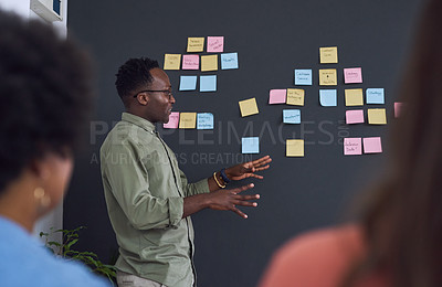 Buy stock photo Meeting, brainstorming and planning with team, black man speaker, sticky note and leader in presentation. Collaboration, teamwork and people in strategy workshop, ideas with presenter and audience