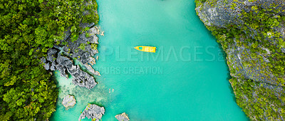 Buy stock photo High angle shot of a boat sailing through a canal running along the Raja Ampat Islands in Indonesia