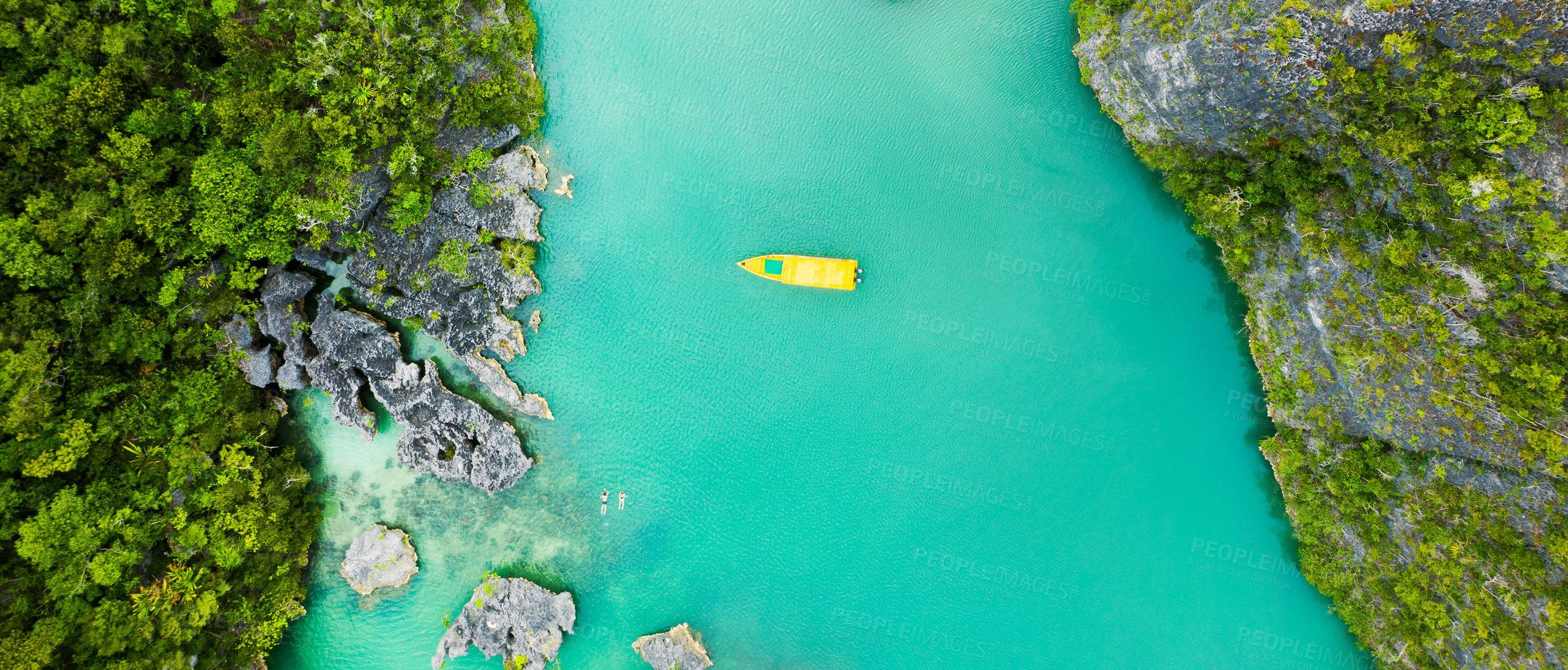 Buy stock photo High angle shot of a boat sailing through a canal running along the Raja Ampat Islands in Indonesia