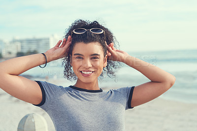 Buy stock photo Cropped shot of a young woman spending the day on the promenade at the beach