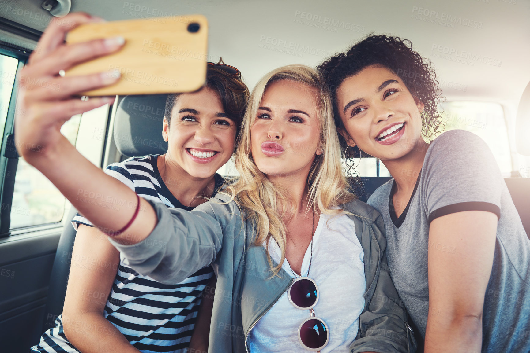 Buy stock photo Cropped shot of young women taking a selfie while out on a road trip together