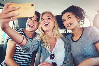 Buy stock photo Cropped shot of young women taking a selfie while out on a road trip together