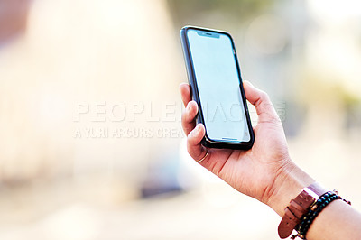 Buy stock photo Cropped shot of an unrecognizable woman using a cellphone while out in the city
