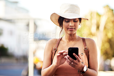 Buy stock photo Shot of an attractive young woman using her cellphone while out in the city