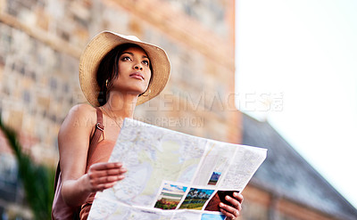 Buy stock photo Shot of an attractive young woman holding a map while exploring in a foreign city