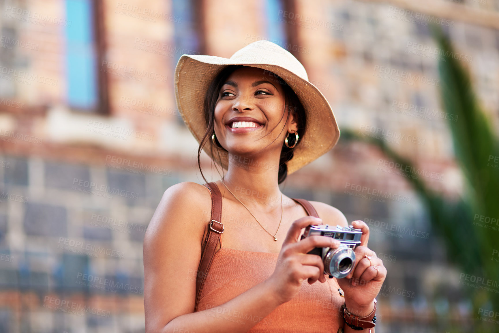 Buy stock photo Shot of an attractive young woman taking pictures with a camera while exploring in a  foreign city