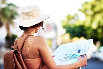 Buy stock photo Rearview shot of an unrecognizable woman holding a map while exploring in a foreign city