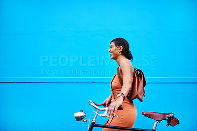 Buy stock photo Shot of an attractive young woman traveling with her bicycle against a blue background