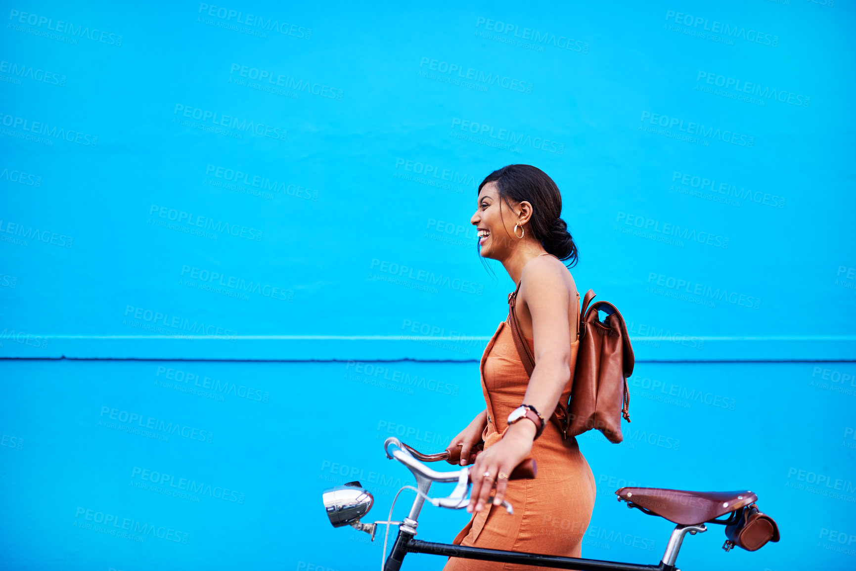 Buy stock photo Bicycle, adventure and woman by wall in city for sustainable transport for travel, journey or sightseeing. Happy, tourism and person with bike on holiday, vacation or trip by blue background in town.