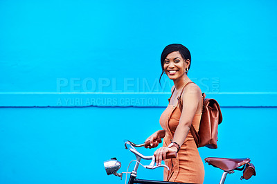 Buy stock photo Portrait of an attractive young woman traveling with her bicycle against a blue background